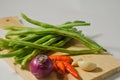 Some green beans, some red chili peppers, two cloves of garlic and a red onion Royalty Free Stock Photo