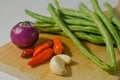 Some green beans, some red chili peppers, two cloves of garlic and a red onion Royalty Free Stock Photo