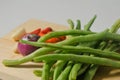 Some green beans, some red chili peppers, two cloves of garlic and a red onion Royalty Free Stock Photo