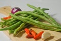 Some green beans, some red chili peppers, two cloves of garlic and a red onion Royalty Free Stock Photo