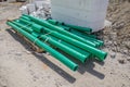 Some green plastic pipes lie on a construction site Royalty Free Stock Photo