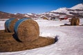 Some hay bales in the snow in Pian grande and Mount Vettore in the background, Castelluccio di Norcia, Umbria, Italy Royalty Free Stock Photo