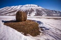 Some hay bales in the snow in Pian grande and Mount Vettore in the background, Castelluccio di Norcia, Umbria, Italy Royalty Free Stock Photo