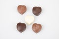 Some heart dark milk chocolate pralines in top view in white background