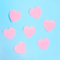 Some heart-shaped pink sticky notes on a blue background.