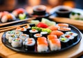 Sushi black plate on a wooden table, blurred background.