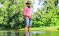 Some kind meditation. Fish normally caught in wild. Trout farm. Fisherman alone stand in river water. Man bearded