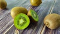 Some kiwi fruit and two half. Tropical green fruit on a wooden table. Close up