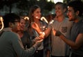 Some light in our lives. a group of cheerful young friends having fun with sparklers together outside at night. Royalty Free Stock Photo