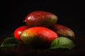 Some mango on wooded board. Black background.