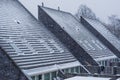 Modern pointed rooftops covered in snow, snowy and cold weather in winter season, new dutch house architecture
