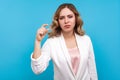 Some more please. Portrait of displeased woman making a little bit gesture and frowning face. blue background