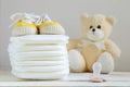 Some nappies on a white wooden table. Sneakers, a pacifier and a teddy bear. Royalty Free Stock Photo