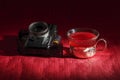 Some old cameras with a roll of film in a reddish environment