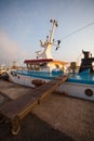 Some old wooden fisher boats are slowly rocking in harbor during a beautiful morning Royalty Free Stock Photo