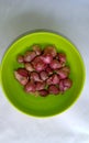 Some onion in green bowl isolated on white background. Blitar city, Indonesia.