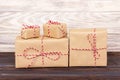 Some paper parcels christmas gift boxes wrapped with paper kraft and tied with red white baker twine in a dark wooden Royalty Free Stock Photo