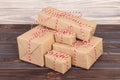 Some paper parcels christmas gift boxes wrapped with paper kraft and tied with red white baker twine in a dark wooden table. Chris Royalty Free Stock Photo