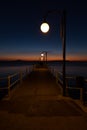 Some people on a pier at Trasimeno lake Umbria, Italy at dusk, with beautiful water reflections and warm colors Royalty Free Stock Photo