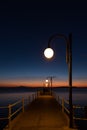 Some people on a pier at Trasimeno lake Umbria, Italy at dusk, with beautiful water reflections and warm colors Royalty Free Stock Photo