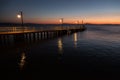 Some people on a pier at Trasimeno lake Umbria, Italy at dusk, with beautiful water reflections and warm colors Royalty Free Stock Photo