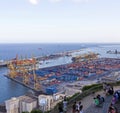 Some people take a rest at the hill Montjuic with a view at the industrial part of the Port of Barcelona