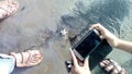 Some people taking picture of the Starfish front side lying on the beach of black sand. Royalty Free Stock Photo