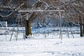 Some playground swings covered in snow . Royalty Free Stock Photo