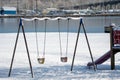 Some playground swings covered in snow . Royalty Free Stock Photo