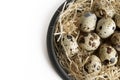 Some quail eggs in a black ceramic bowl