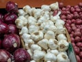 Red onions, garlic, and red potatoes sit in a grocery store prod Royalty Free Stock Photo