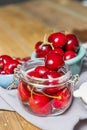 some ripe canned cherries in a clear glass jar with a lid next Royalty Free Stock Photo