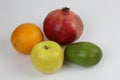 Some ripe fruit on a white background: pomegranate, pomelo, orange, avocado, Apple Royalty Free Stock Photo