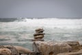 some rocks are stacked together on some logs by the ocean