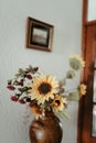 some sunflowers are in a vase and another framed picture