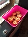 Some sweet round cookies in a pink plastic box