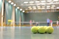 Some tennis balls on tennis court in sports hall, Royalty Free Stock Photo