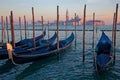 Some traditional gondolas at quay in front of San Giorgio Maggiore island at sunset Royalty Free Stock Photo