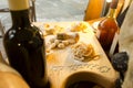 Some types of dough products lie on a wooden board surrounded by bottles of wine