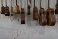 Some unfinished customed guitars and ukuleles hanging on finishing room at classical guitar workshop owned by I Wayan Tuges