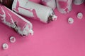 Some used pink aerosol spray cans and nozzles with paint drips lies on a blanket of soft and furry light pink fleece fabric. Class Royalty Free Stock Photo