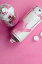Some used pink aerosol spray cans and nozzles with paint drips lies on a blanket of soft and furry light pink fleece fabric. Class Royalty Free Stock Photo