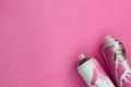 Some used pink aerosol spray cans with paint drips lies on a blanket of soft and furry light pink fleece fabric. Classic female de