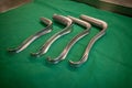 Some various specula are placed on an operating table for performing a gynecological examination