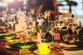 Some wine glasses, plates, forks and green briefcases for event celebration. Beautiful dinner table setting. Vintage decoration of