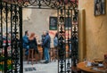 Some women and men having drinks and lunch at outdoor restaurant on old spanish street