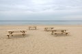 Some wooden tables and benches on empty sandy beach on Baltic sea in Jurmala at the end of summer season