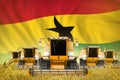 Some yellow farming combine harvesters on rye field with Ghana flag background - front view, stop starving concept - industrial 3D