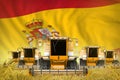 Industrial 3D illustration of some yellow farming combine harvesters on rural field with Spain flag background - front view, stop