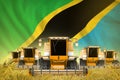 some yellow farming combine harvesters on wheat field with Tanzania flag background - front view, stop starving concept -
